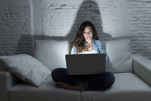 Atrakcyjna kobieta zrelaksowany w domu siedzący szczęśliwy na kanapie przy użyciu laptopa w ciemny wieczór — Zdjęcie stockowe