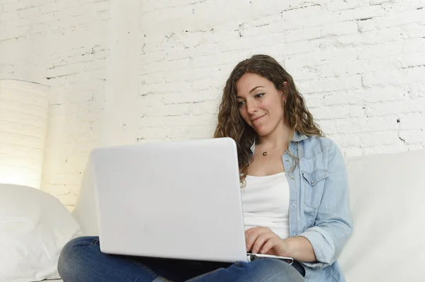 Young attractive spanish woman using laptop computer sitting relaxed working on home couch — Stock Photo, Image