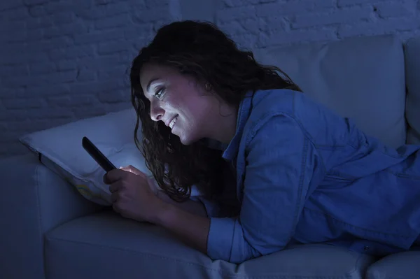 Jeune belle femme couchée sur le canapé à la maison en utilisant le concept de dépendance Internet de téléphone mobile — Photo