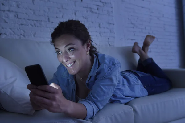 Fiatal gyönyörű nő feküdt otthon a kanapén használ mozgatható telefon internet függőség fogalma — Stock Fotó