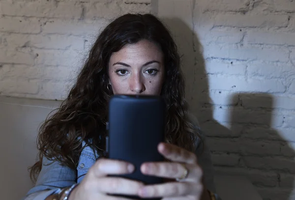 Hispânico mulher segurando telefone celular em olhos loucos rede social e internet vício conceito — Fotografia de Stock