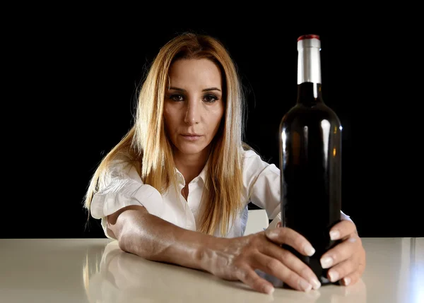 Пьяная блондинка-алкоголичка, одинокая в депрессии, подавленная бутылкой красного вина с похмельем — стоковое фото