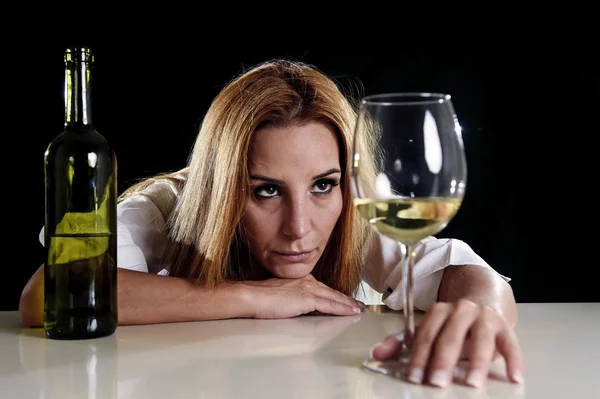 Ubriaca donna bionda alcolizzata da sola in depresso sprecato guardando premuroso al bicchiere di vino bianco — Foto Stock