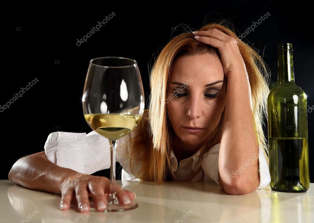Drunk alcoholic blond woman alone in wasted depressed drinking white