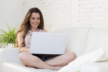 mutlu gülümseyerek veya Internet online alışveriş yaparken dizüstü bilgisayar ile çalışan genç güzel kadın