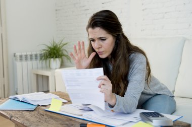 young worried woman suffering stress doing domestic accounting paperwork bills