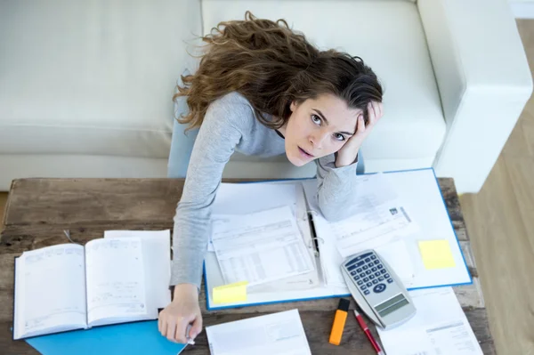 Worried woman suffering stress doing domestic accounting paperwork bills and invoices Stockfoto