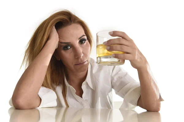 Кавказская блондинка, пьяная и подавленная алкоголичка, пьющая скотч, виски, стакан. Лицензионные Стоковые Изображения