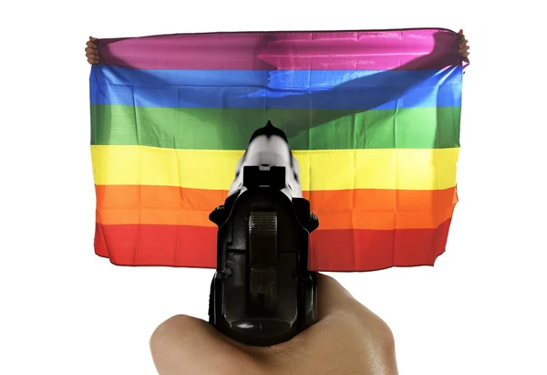 Nietolerancji gwałtowne reprezentację ataku terrorystycznego z rąk wskazującego pistolet na flagę dumny gej gospodarstwa — Zdjęcie stockowe