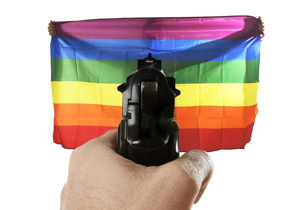 Нетерпимость насильственное представление террористической атаки с ручным наведением пистолета на гордый гей, держащий флаг — стоковое фото