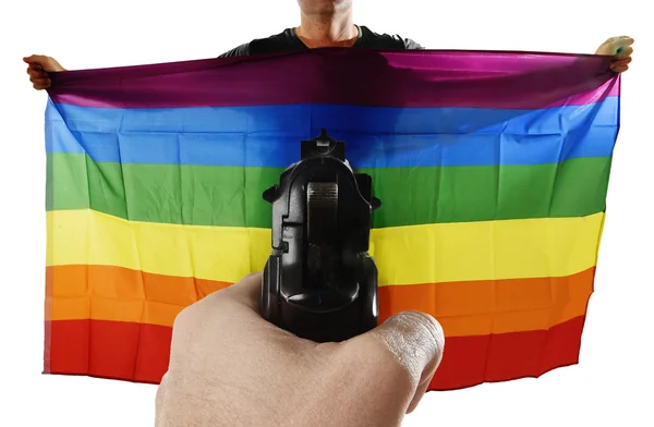 Intolerância representação violenta de ataque terrorista com mão apontando arma em orgulhoso gay segurando bandeira — Fotografia de Stock