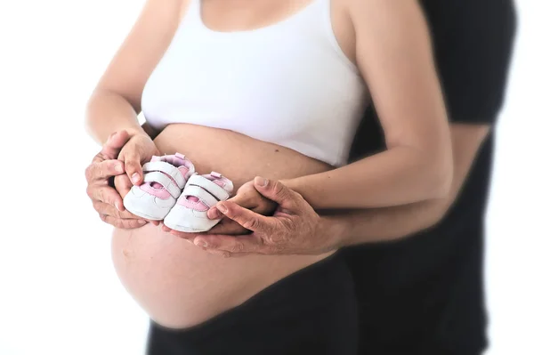 Pasangan dengan wanita hamil memegang dengan tangan bersama bayi yang baru lahir sepatu untuk putri yang akan datang — Stok Foto