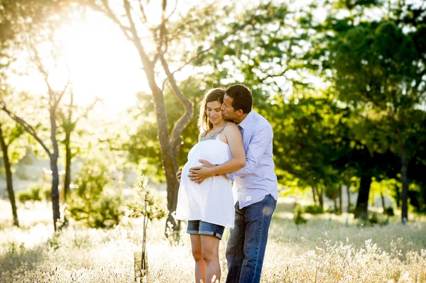 Young happy couple in love together on park landscape sunset with woman pregnant belly Royalty Free Stock Photos
