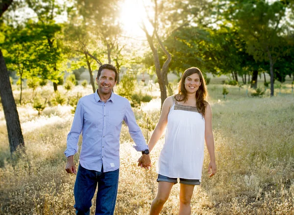 恋女性妊娠中の腹の公園風景夕日で一緒に幸せなカップル — ストック写真