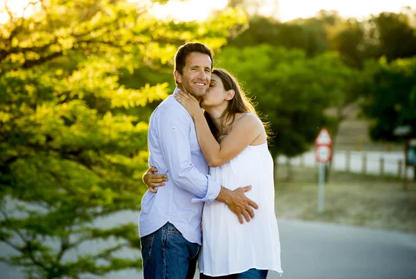 Feliz pareja en el amor juntos en el paisaje del parque en la puesta del sol con la mujer embarazada vientre y el hombre — Foto de Stock