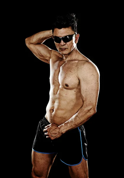 Attractive sport man with fit strong bodybuilder body posing cool in corporate gym portrait with sunglasses — Stock Photo, Image