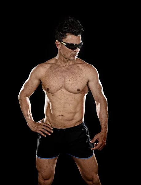 Attractive sport man with fit strong bodybuilder body posing cool in corporate gym portrait with sunglasses — Stock Photo, Image