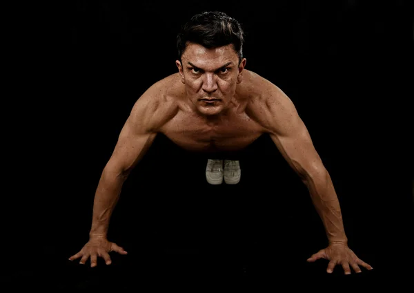 Hombre deportivo fuerte en forma haciendo ejercicio push up en el gimnasio posando con el torso desnudo arrancado hombros —  Fotos de Stock