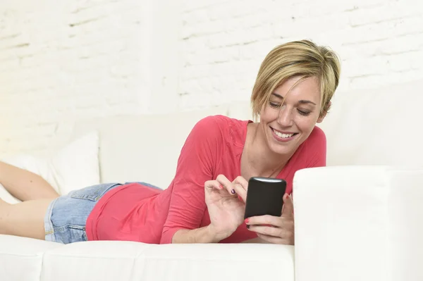 Jovem bela mulher caucasiana mensagens de texto feliz usando a internet no telefone móvel relaxado — Fotografia de Stock