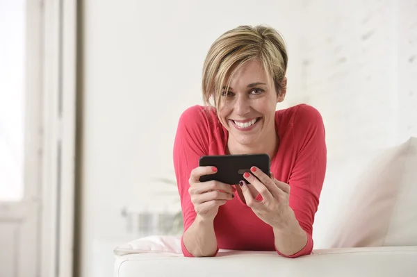 Joven hermosa mujer caucásica feliz usando aplicación de Internet en el teléfono móvil sonriendo feliz — Foto de Stock