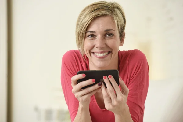 Young beautiful Caucasian woman happy using internet app on mobile phone smiling happy — Stok fotoğraf