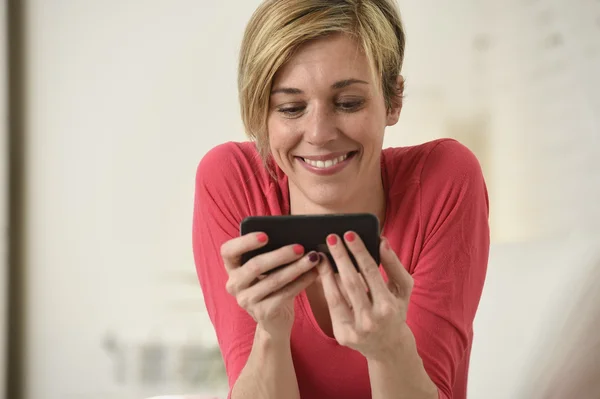 Joven hermosa mujer caucásica feliz usando aplicación de Internet en el teléfono móvil sonriendo feliz — Foto de Stock