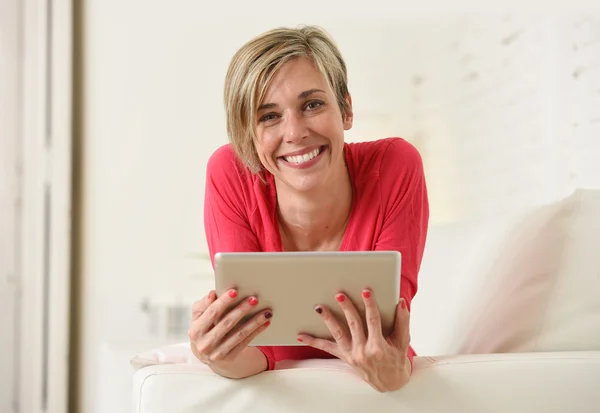 Young beautiful happy 30s woman smiling using digital tablet pad at home living room couch — Stock fotografie