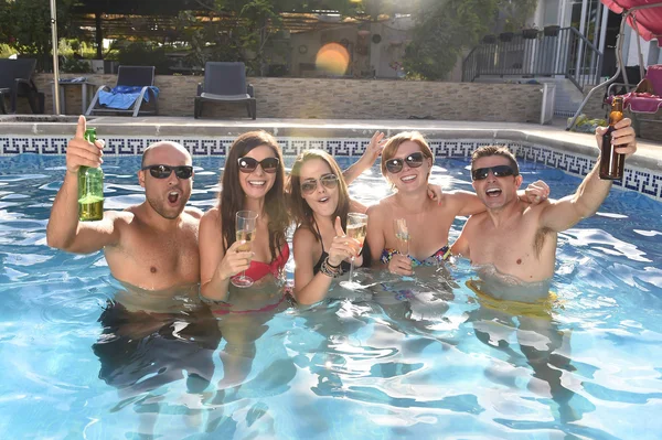 Щасливі привабливі чоловіки і жінки в бікіні купаються в готельному курорті басейн пиво — стокове фото