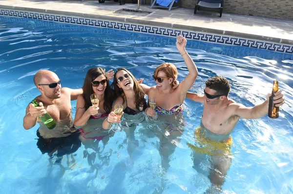 Happy attractive men and women in bikini having bath at hotel resort swimming pool drinking beer — Stock Photo, Image