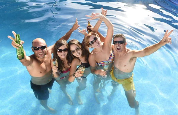 Счастливые привлекательные мужчины и женщины в бикини, купающиеся в бассейне отеля, пьющие пиво — стоковое фото
