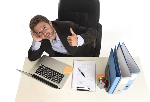 Молодой привлекательный бизнесмен счастлив и уверен в себе в офисе, работая на ноутбуке — стоковое фото