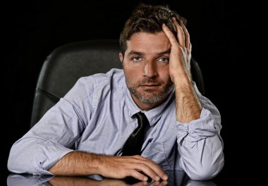 young attractive businessman in worried tired and stressed face expression sitting depressed on office chair