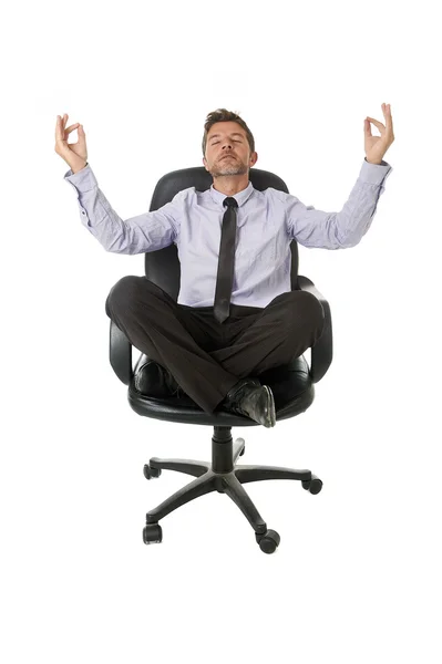 Young attractive happy businessman relaxing with hands in yoga position sitting on office chair — Zdjęcie stockowe