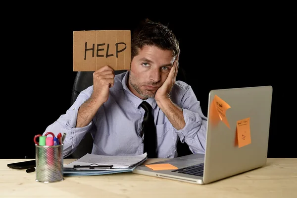 Stanco uomo d'affari disperato sotto stress che lavora alla scrivania del computer ufficio con un cartello che chiede aiuto — Foto Stock