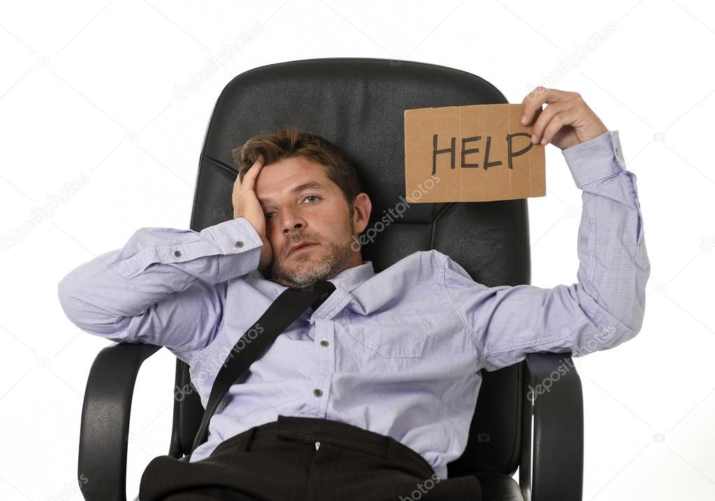young attractive tired and wasted businessman sitting on office chair asking for help in stress 