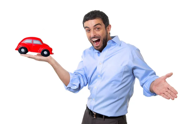 Young happy attractive man pointing big red toy car on his hand — Stock Photo, Image