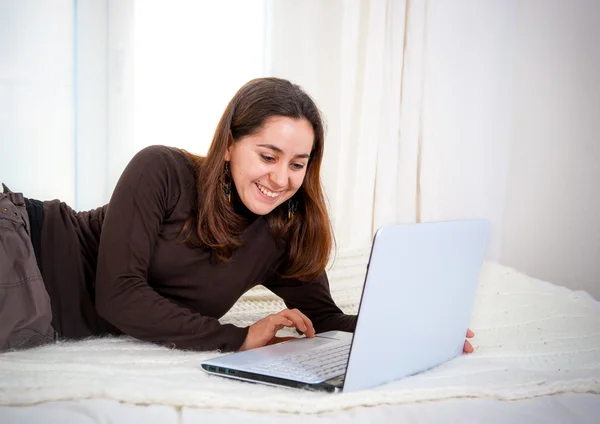Kobieta latin szczęśliwy brązowe włosy, działa na jej laptopie — Zdjęcie stockowe
