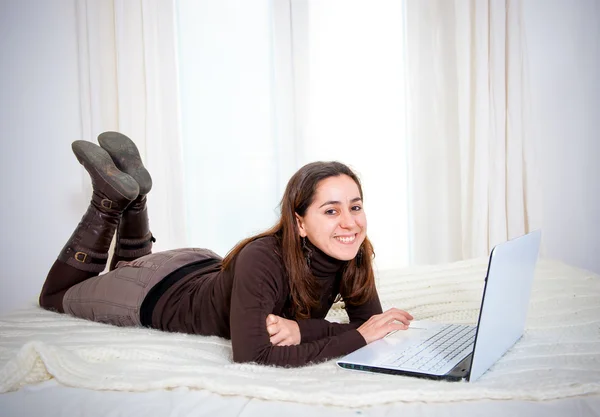 Feliz cabello castaño mujer latina trabajando en su portátil —  Fotos de Stock