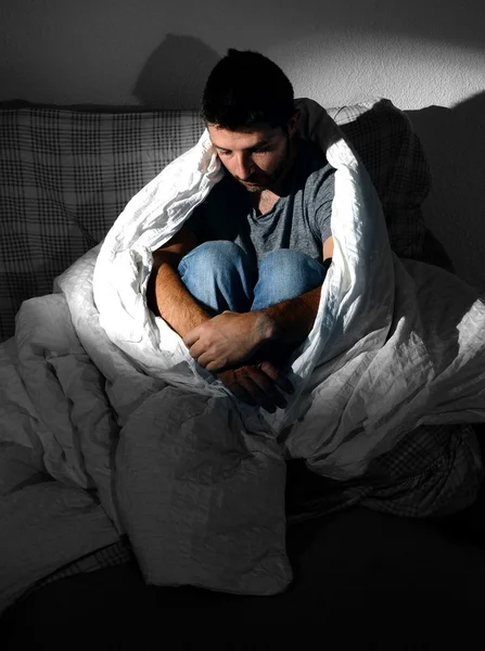 Jeune homme assis sur le canapé à la maison souffrant de dépression et de crise — Photo
