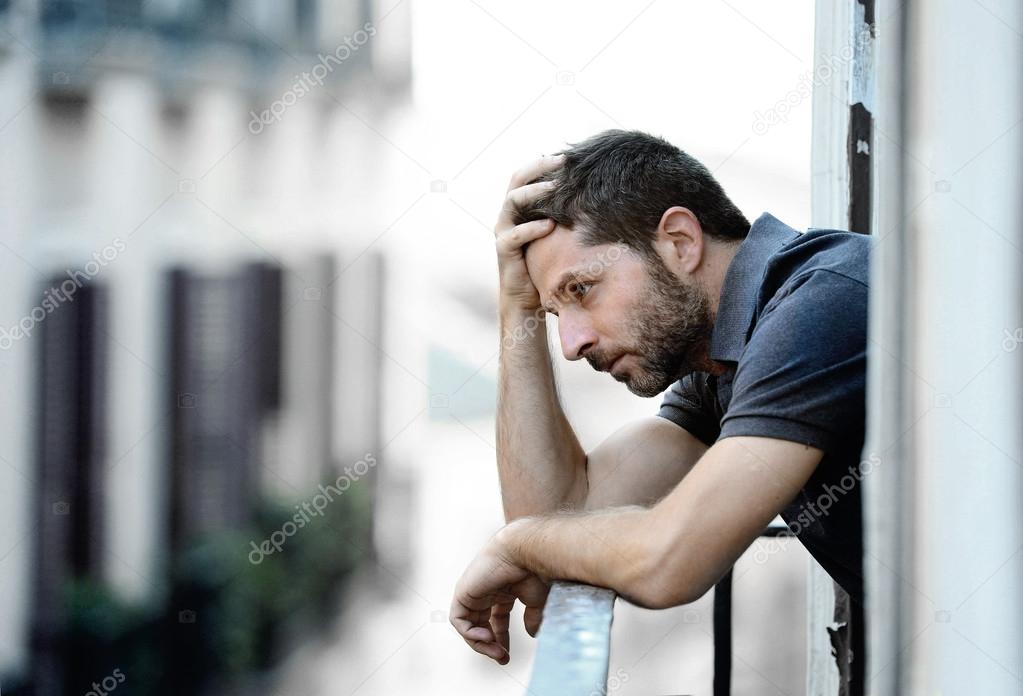 young man at balcony in depression suffering emotional crisis and grief