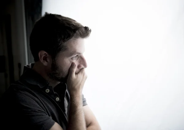 Pria yang menarik bersandar pada jendela yang menderita krisis emosional dan depresi — Stok Foto