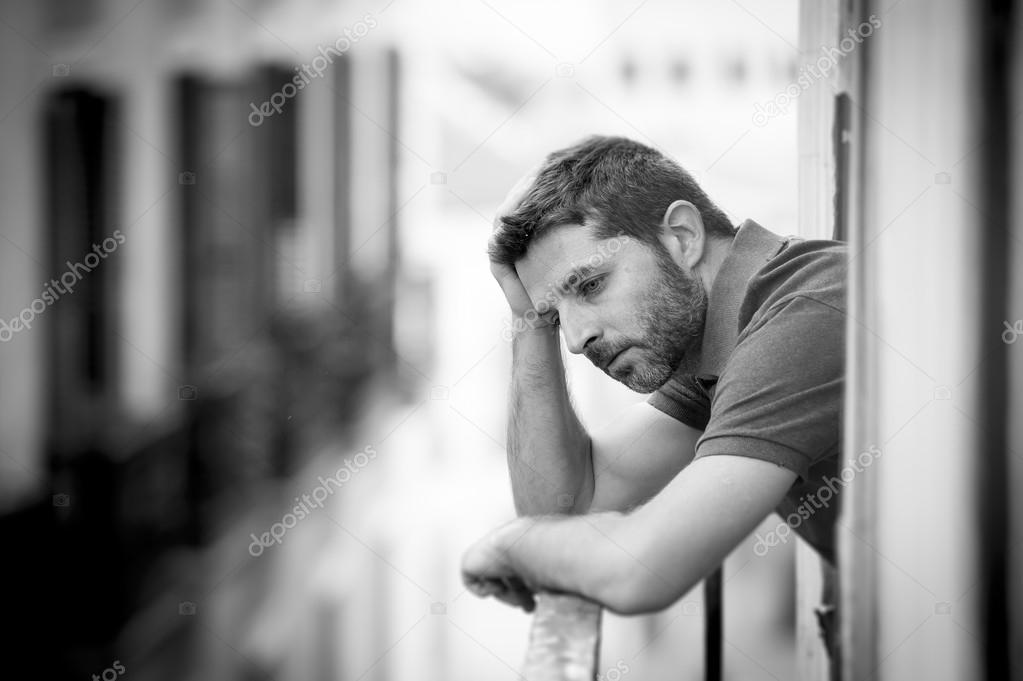  young man at balcony in depression suffering emotional crisis
