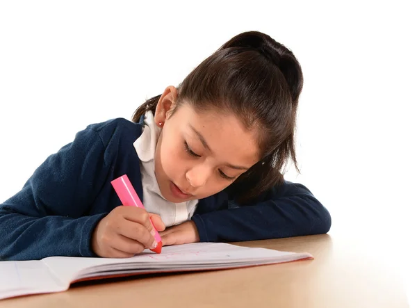 Kleines hispanisches Kind schreibt und Hausaufgaben mit rosa Filzstift macht — Stockfoto