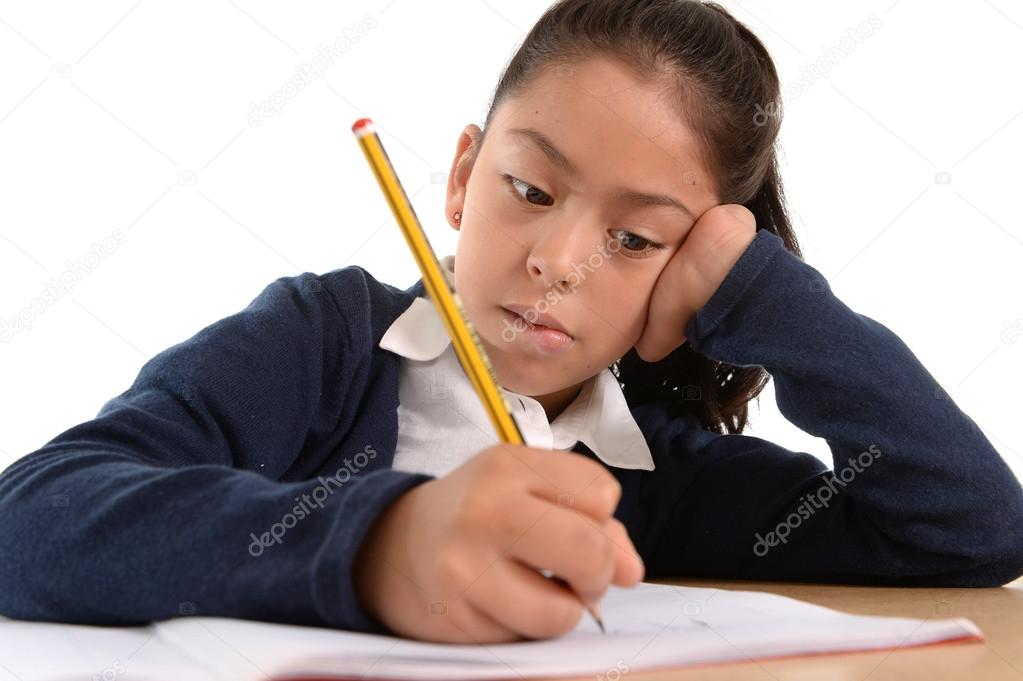 hispanic female child writing carefully homework with pencil with  concentrated face