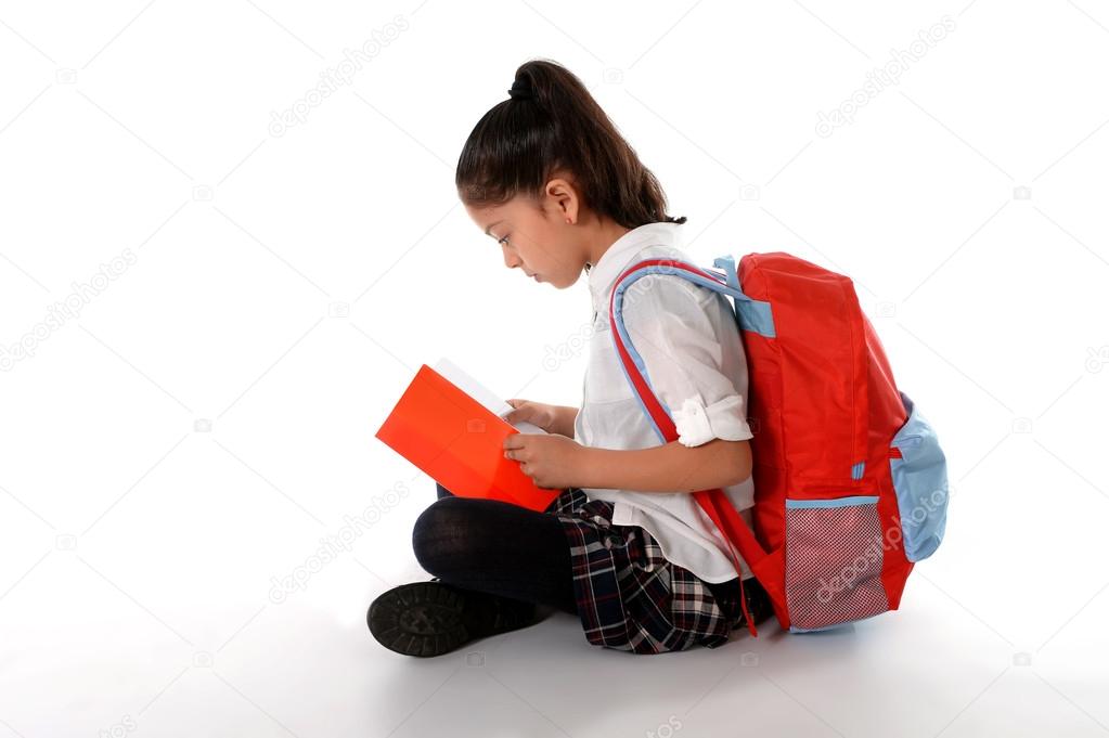 latin child reading textbook or notepad smiling sitting on the floor 