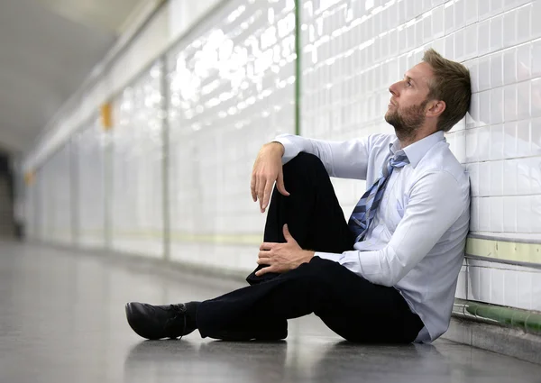 Jonge zakenman verloren in depressie zittend op grond straat metro — Stockfoto