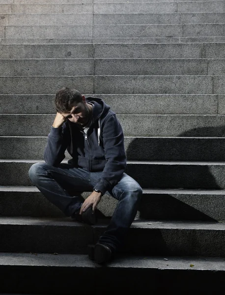 Mladý muž v deprese sedí na zemi ulici betonové schody — Stock fotografie