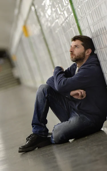 Jonge man verloren in depressie zittend op grond straat metro tunnel — Stockfoto