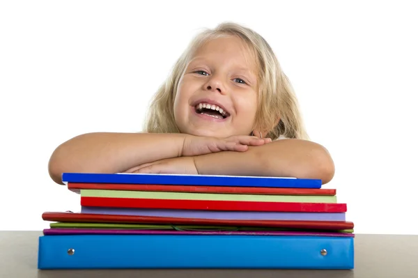 Nettes kleines Schulmädchen glücklich auf dem Schreibtisch, entspannt auf Bücher gestützt — Stockfoto