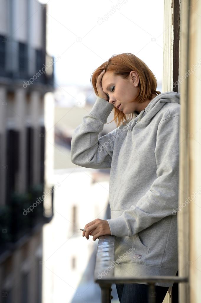 Attractive woman suffering depression and stress outdoors at the balcony